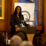 Photo of Barbara Mills KC at a lectern talking to an audience